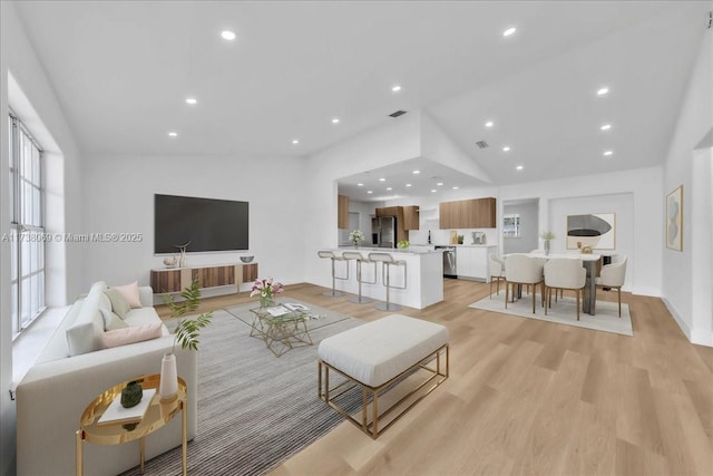 living room with vaulted ceiling and light hardwood / wood-style floors