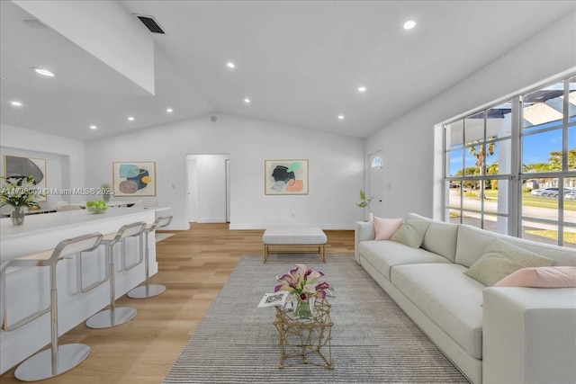 living room with vaulted ceiling and light wood-type flooring