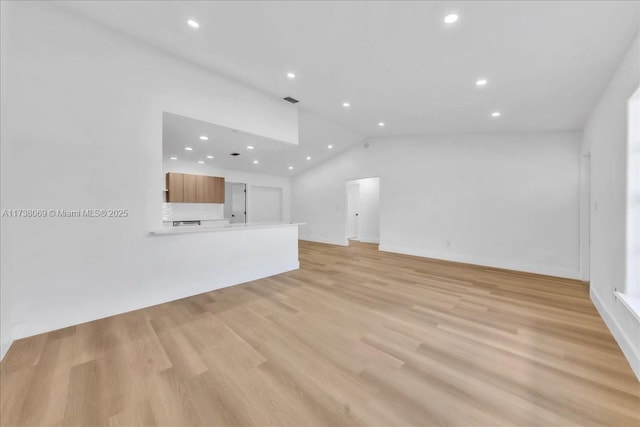 unfurnished living room with vaulted ceiling and light hardwood / wood-style floors