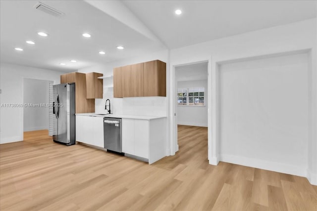 kitchen featuring white cabinetry, appliances with stainless steel finishes, sink, and light hardwood / wood-style floors