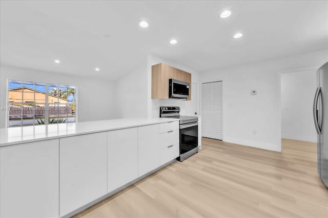 kitchen featuring white cabinetry, light brown cabinetry, light hardwood / wood-style flooring, and appliances with stainless steel finishes