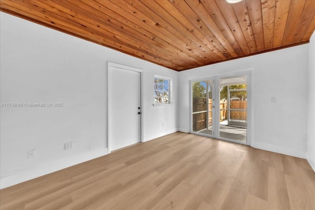 spare room featuring light wood-type flooring, wood ceiling, and french doors