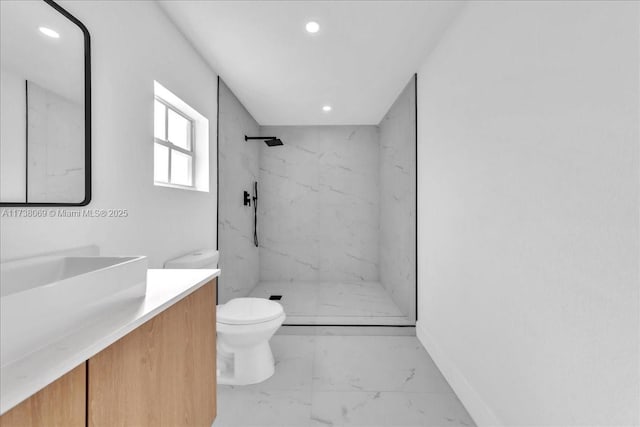 bathroom with vanity, tiled shower, and toilet