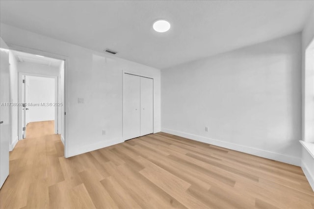 unfurnished bedroom with light hardwood / wood-style flooring and a closet