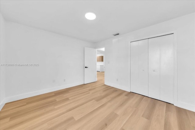 unfurnished bedroom featuring a closet and light wood-type flooring