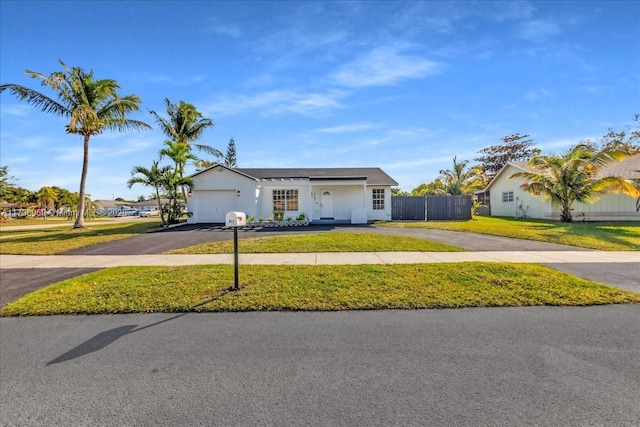 single story home with a garage and a front lawn