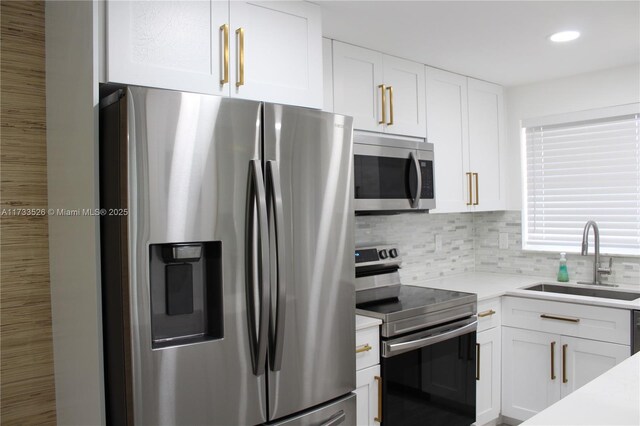 kitchen featuring appliances with stainless steel finishes, sink, decorative backsplash, and white cabinets