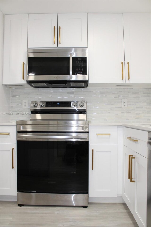 kitchen featuring white cabinetry, appliances with stainless steel finishes, and decorative backsplash