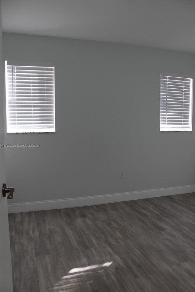 spare room featuring dark wood-type flooring