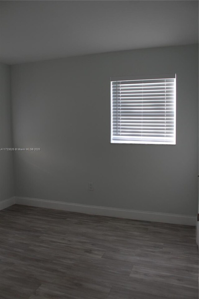 spare room with dark wood-type flooring