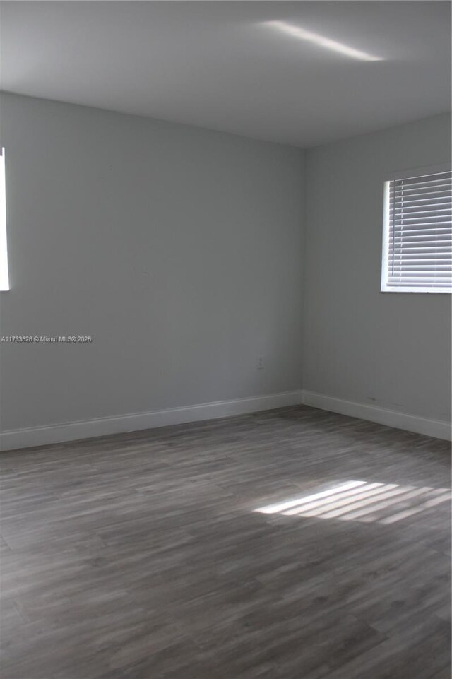 unfurnished room with dark hardwood / wood-style floors