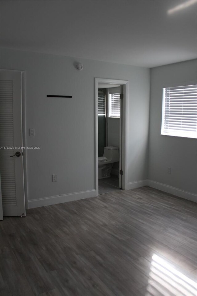 empty room with dark hardwood / wood-style flooring