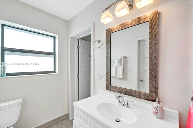 bathroom featuring vanity, toilet, and hardwood / wood-style floors