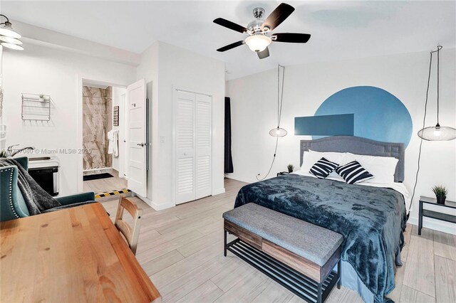 bedroom featuring light hardwood / wood-style floors, ceiling fan, and ensuite bathroom