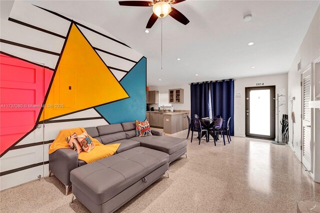 living room featuring ceiling fan and sink