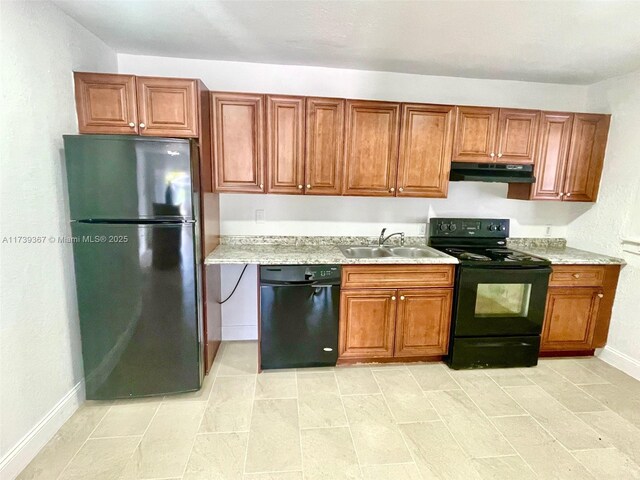 kitchen featuring light stone countertops, sink, and black appliances