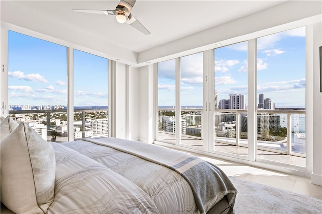 tiled bedroom with ceiling fan and multiple windows