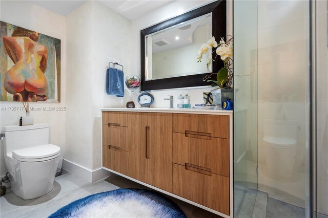 bathroom with vanity, toilet, and a shower with shower door