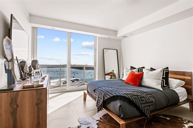 bedroom featuring a water view and light tile patterned floors