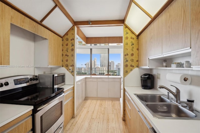 kitchen featuring sink, lofted ceiling with beams, stainless steel appliances, and light hardwood / wood-style floors