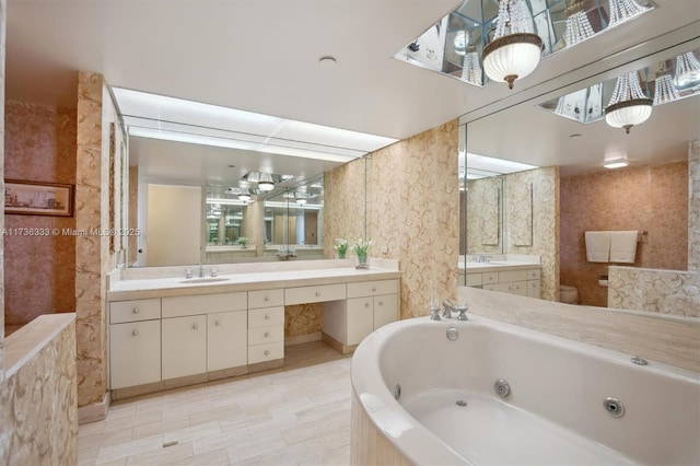 bathroom featuring vanity and tiled bath