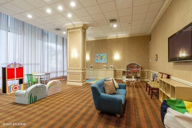 interior space with crown molding, carpet floors, and ornate columns