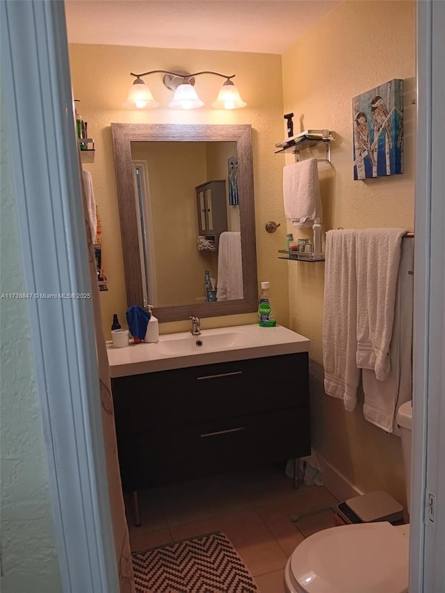 bathroom featuring vanity, tile patterned floors, and toilet