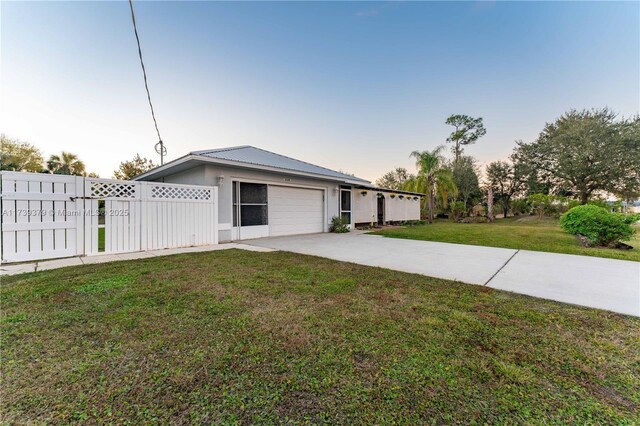 ranch-style home with a garage and a yard