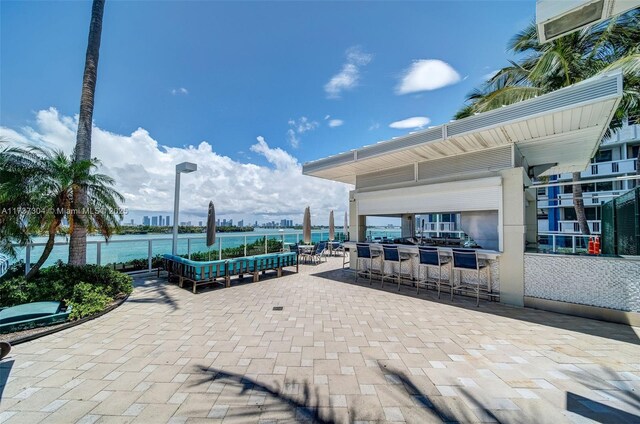 view of patio featuring a water view and an outdoor bar