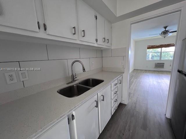 kitchen with backsplash, ceiling fan, sink, and white cabinets