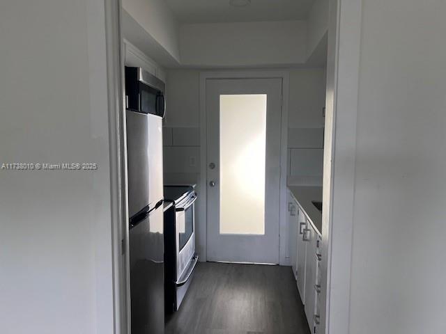 kitchen featuring white cabinetry, stainless steel appliances, and dark hardwood / wood-style floors