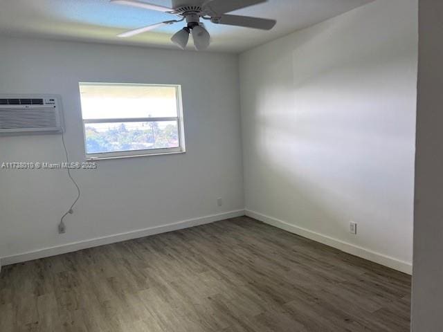 spare room with ceiling fan, dark hardwood / wood-style flooring, and a wall mounted AC