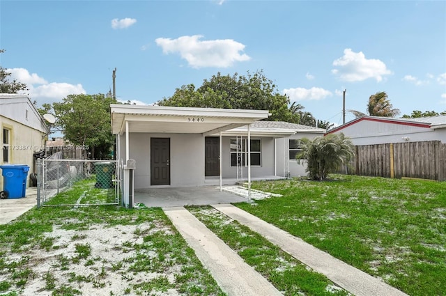 rear view of house featuring a carport and a lawn