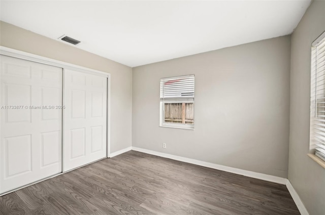 unfurnished bedroom featuring wood-type flooring and a closet