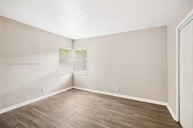 unfurnished bedroom with dark hardwood / wood-style floors and a closet