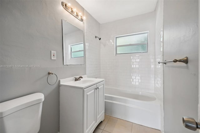 full bathroom featuring tile patterned flooring, vanity, tiled shower / bath combo, and toilet