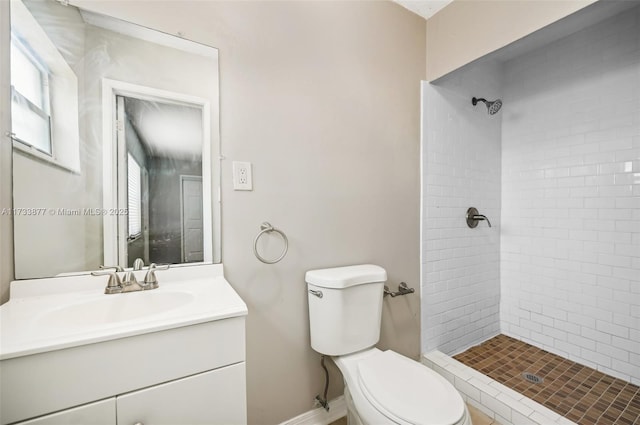 bathroom featuring tiled shower, vanity, and toilet