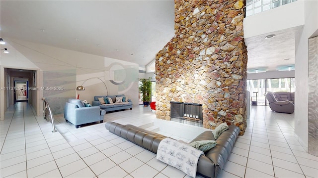 tiled living room featuring a towering ceiling and a fireplace