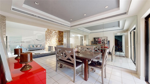 tiled dining space featuring a tray ceiling