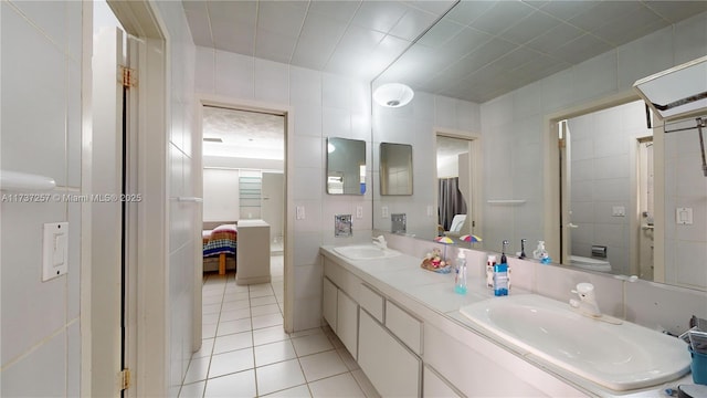 bathroom featuring vanity, tile walls, tile patterned floors, and toilet