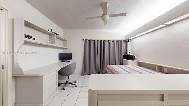 home office with ceiling fan, built in desk, a textured ceiling, and light tile patterned floors