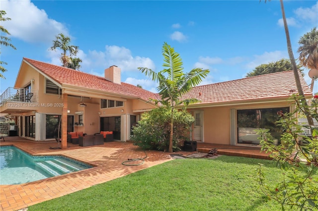 rear view of house featuring a balcony, an outdoor hangout area, a yard, and a patio area