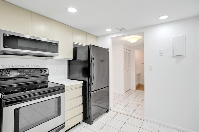 kitchen featuring cream cabinetry, stainless steel appliances, and light tile patterned floors