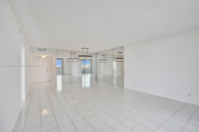 tiled empty room with a textured ceiling