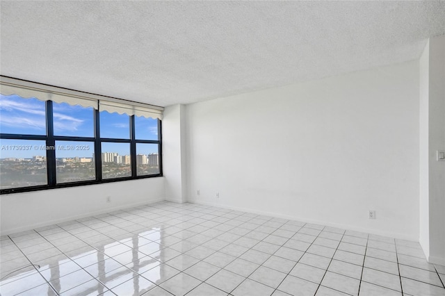 unfurnished room with light tile patterned floors and a textured ceiling