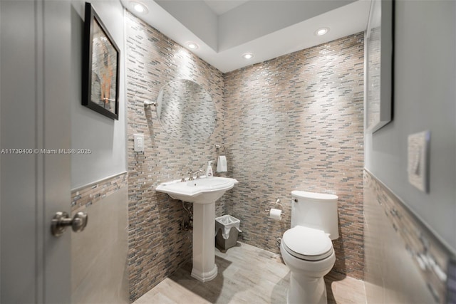 bathroom with tile walls and toilet