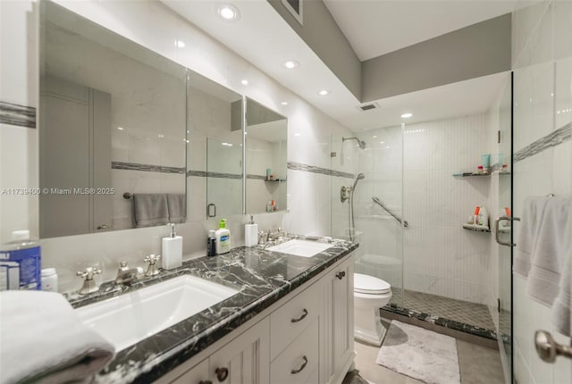 bathroom with tasteful backsplash, toilet, vanity, and a shower with shower door