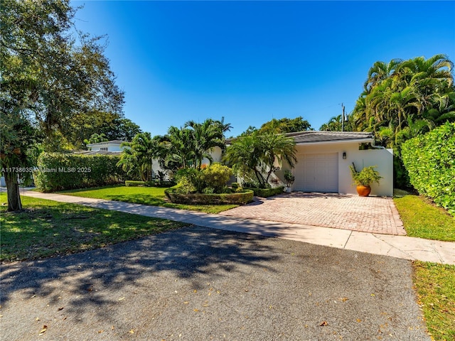 view of front of property with a garage and a front lawn