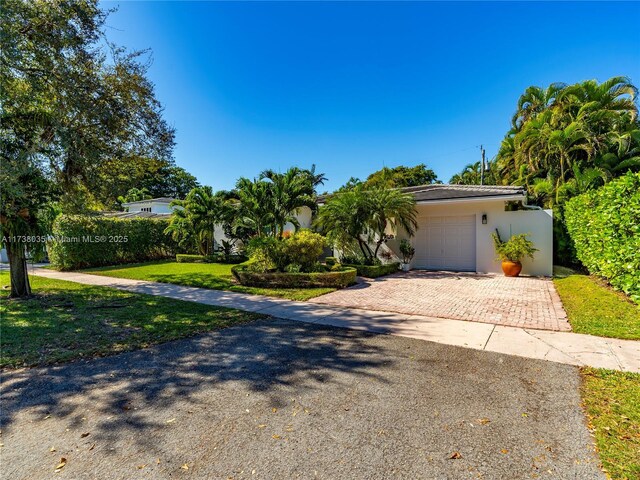 view of front of house with a garage and a front yard