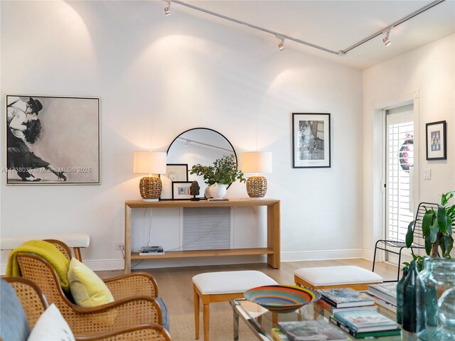 sitting room with hardwood / wood-style floors and rail lighting